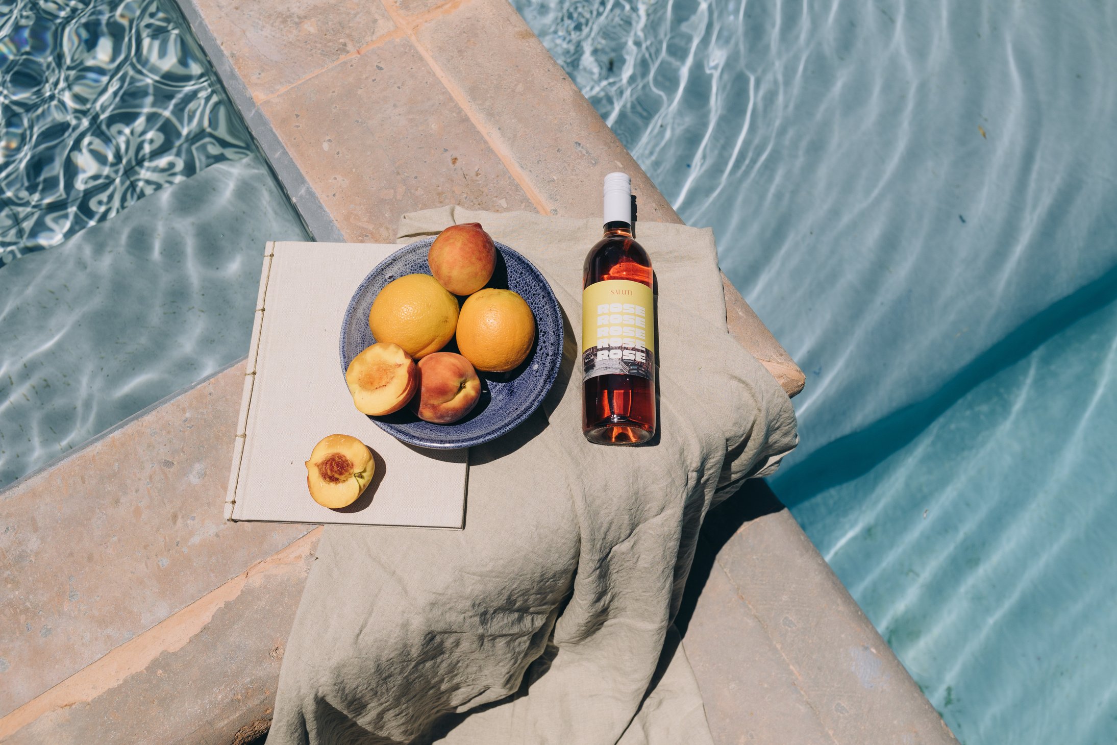 Peaches and Bottle of Wine by the Swimming Pool